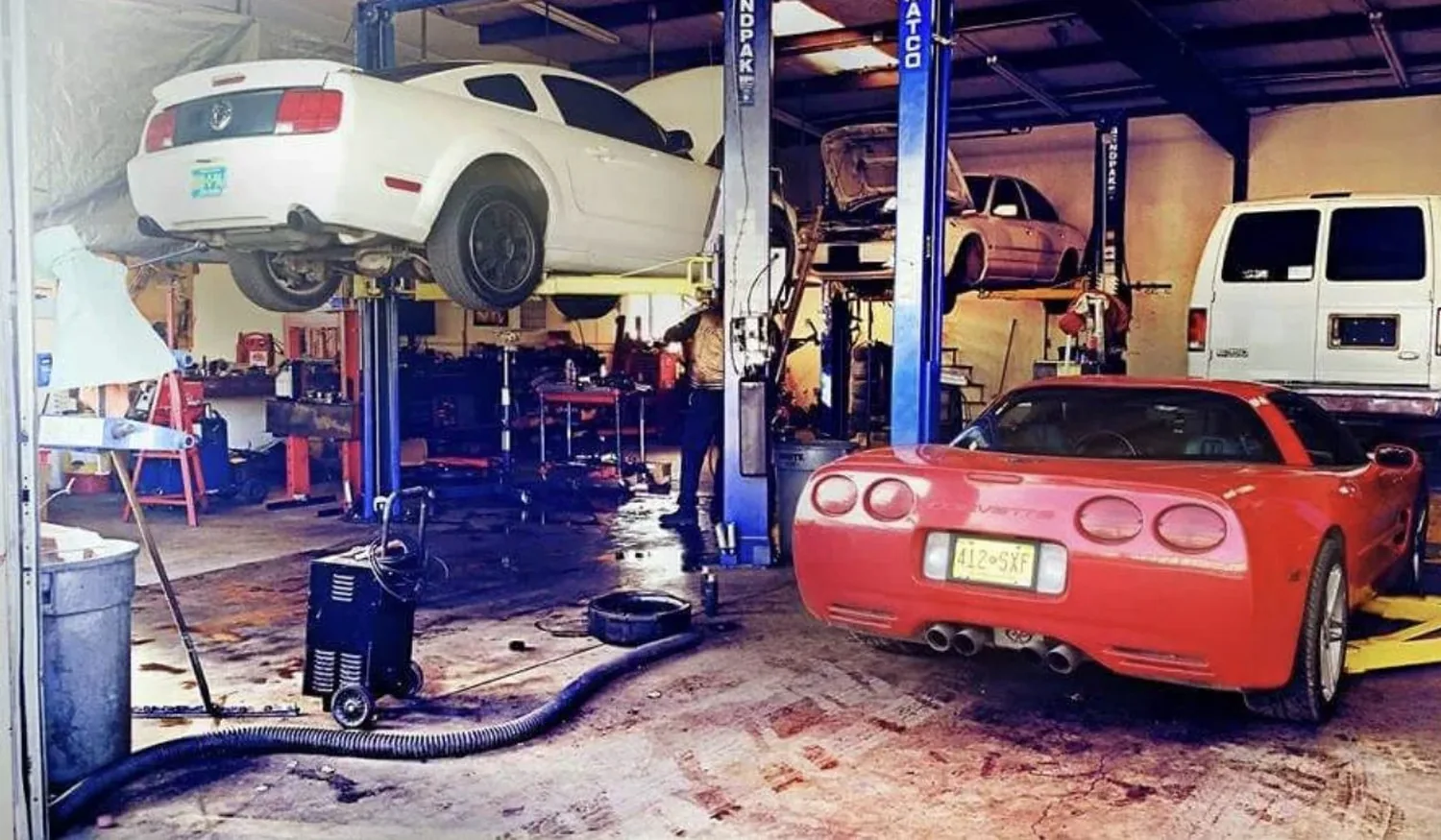 Four bays at Rafa's Auto Repair, cars up on the lifts.